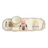 A decorative ceramic tea cup with a matching long rectangular tray featuring illustrated nutcracker and fairy characters, shown on a plain white background.