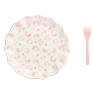 Round plate with pink floral pattern and a pink spoon on a white background