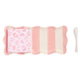 Pink and white striped plate with a pink patterned napkin and white spoon on a white background