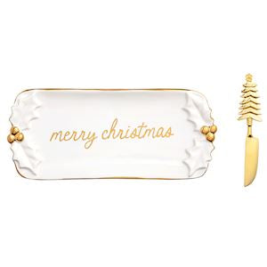 A white ceramic Christmas-themed serving tray with gold trim and the words 'merry christmas' in gold script, shown alongside a matching gold knife with a tree-shaped handle on a white background.