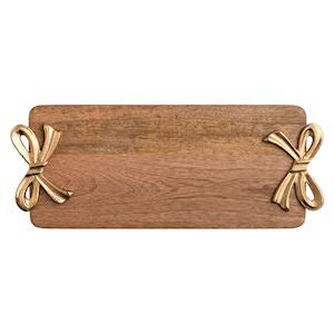 A rectangular wooden serving board with rounded corners and two decorative metallic bow handles, shown on a plain white background.