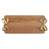 A rectangular wooden serving board with rounded corners and two decorative metallic bow handles, shown on a plain white background.