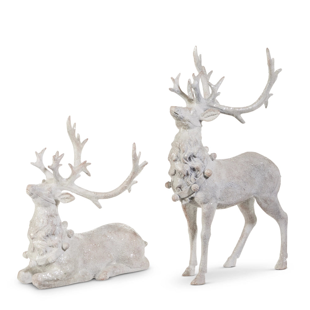 Two white deer figurines with intricate antlers on a white background