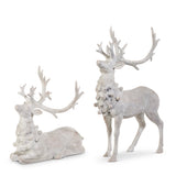 Two white deer figurines with intricate antlers on a white background