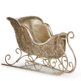 Decorative metal sleigh with intricate designs on a white background