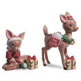 Two decorative deer figurines with Christmas accessories on a white background