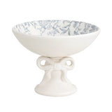 White ceramic footed bowl with blue floral pattern on a white background