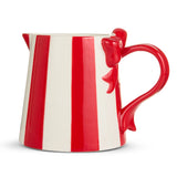 Red and white striped pitcher with a handle shaped like a bow on a white background