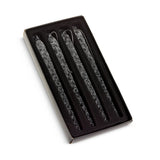 Set of three decorative candles in a black box on a white background