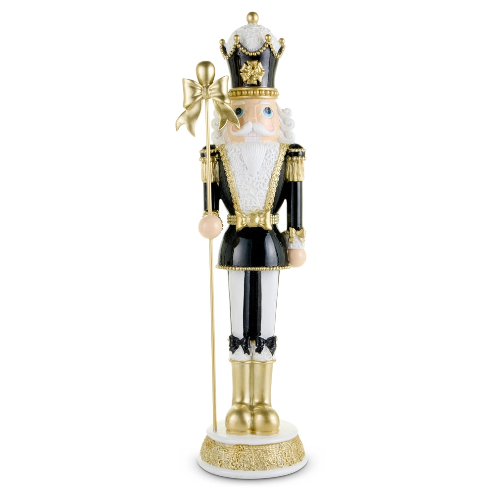Decorative nutcracker figure with gold, black, and white attire on a white background