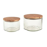 Two glass jars with wooden lids on a white background