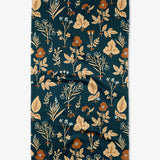 Floral patterned fabric with leaves and flowers on a dark blue background