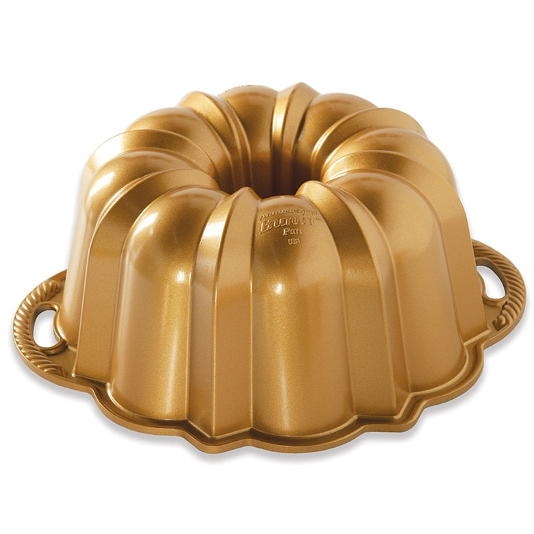 Gold Bundt cake pan on a white background