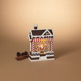 Decorative house-shaped lantern with Santa Claus figure on a beige background