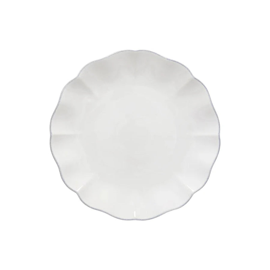 White ceramic plate with scalloped edge on a white background
