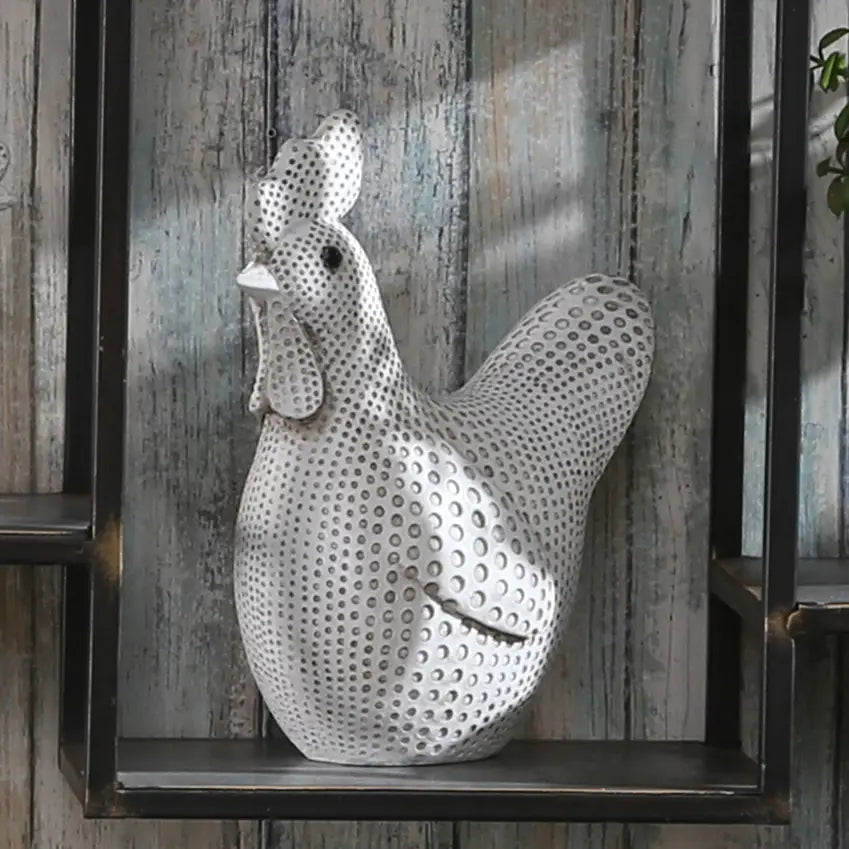 Decorative metal rooster sculpture on a wooden shelf