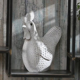 Decorative metal rooster sculpture on a wooden shelf