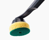 Close-up of a cleaning brush with a yellow and green sponge head on a white background