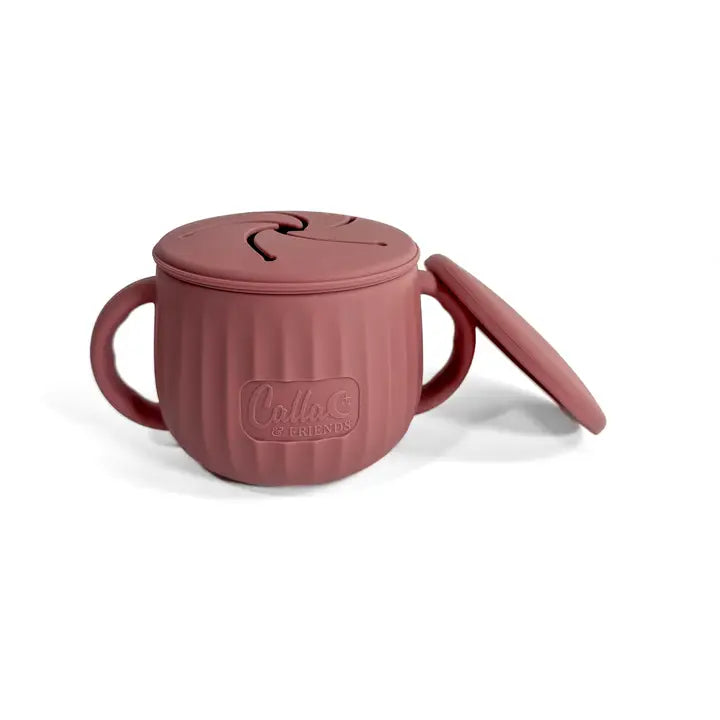 Pink sippy cup with handle and lid on a white background