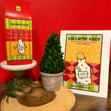Ala carte Alice packaging with a plant and wooden board against a red wall