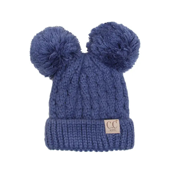 Blue knit beanie with two pom-poms on a white background