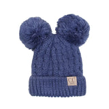 Blue knit beanie with two pom-poms on a white background