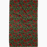 Patterned fabric with red berries and green leaves on a dark background
