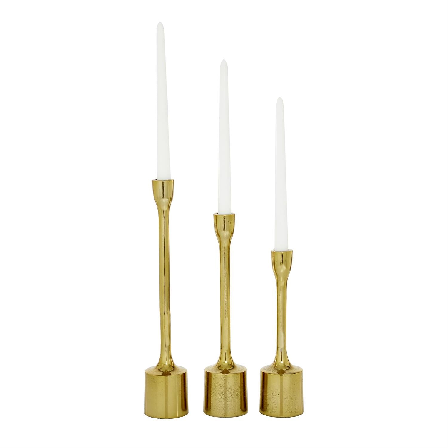 Three gold candle holders with white candles on a white background
