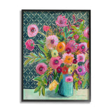 A framed floral art print featuring a colorful bouquet of pink, orange, yellow, and purple flowers in a turquoise vase against a dark patterned background, shown on a white wall.