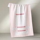 Pink kitchen towel with recipe illustrations on a white background