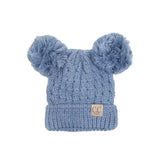 Blue knitted hat with two fluffy pom-poms on a white background