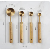 Set of four brass measuring spoons with wooden handles, shown with measurements on a white background.
