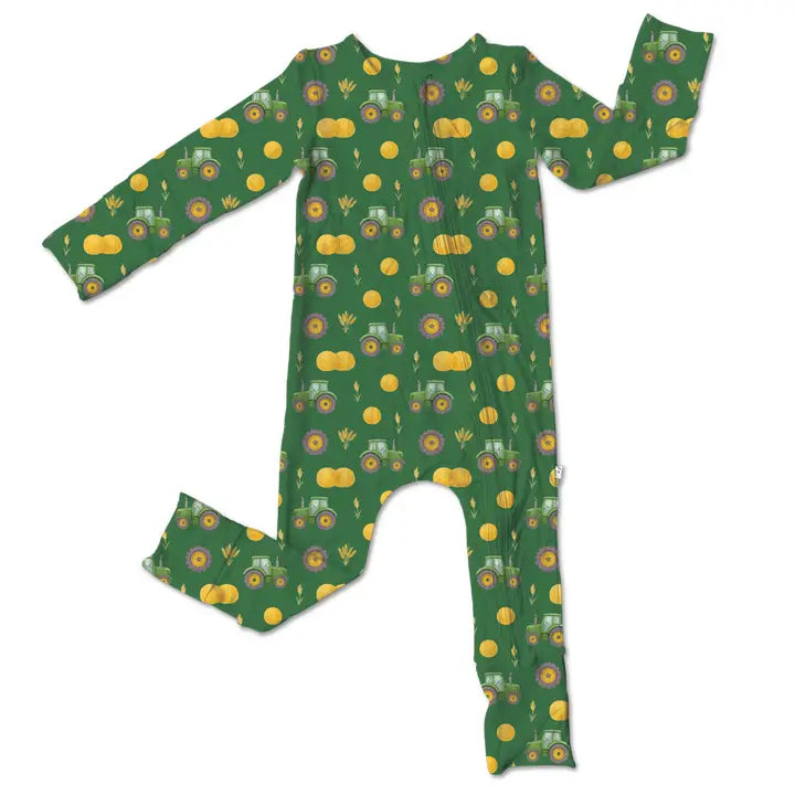 Green baby onesie with tractor and pumpkin pattern on a white background