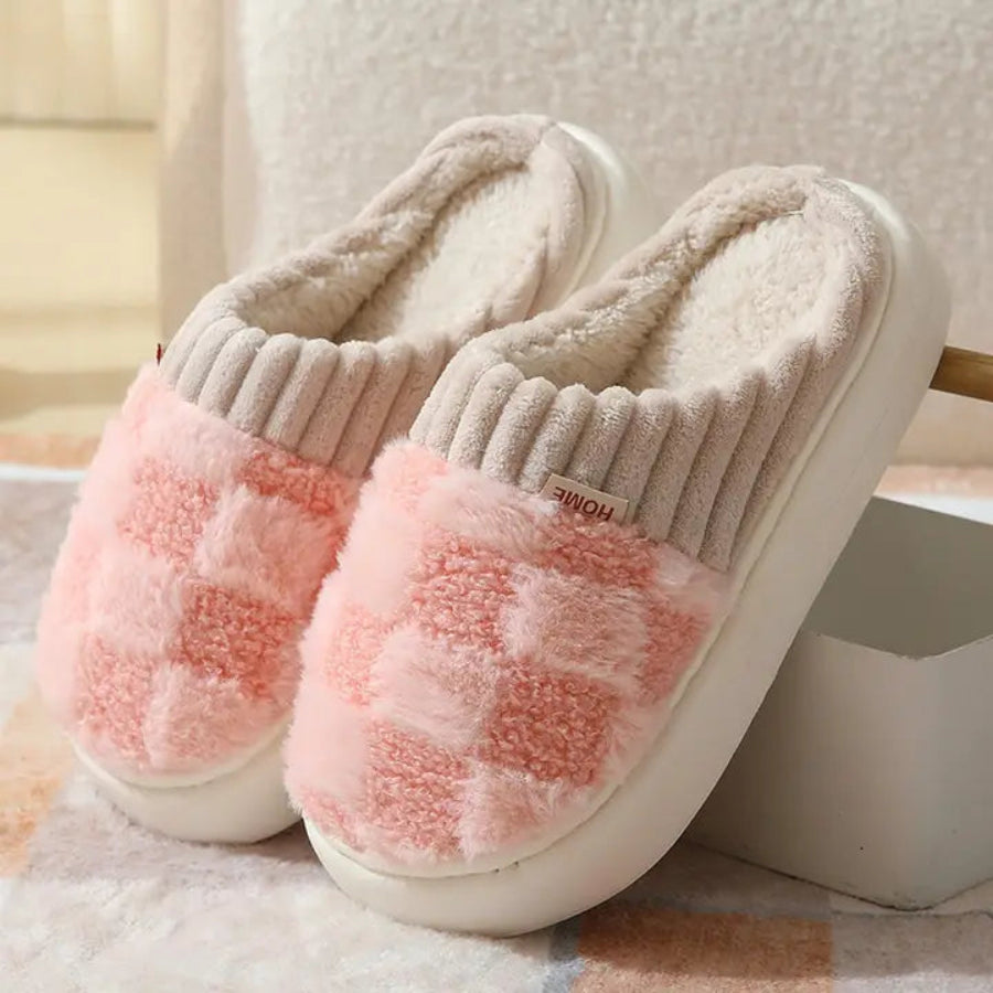 Pair of pink and beige slippers on a soft surface