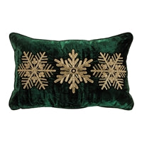 Green pillow with gold snowflake patterns on a white background