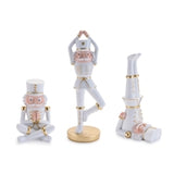 Three ceramic nutcrackers in yoga poses on a white background