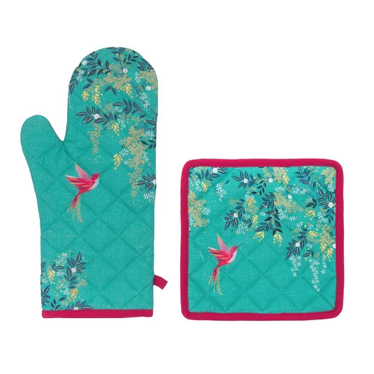A quilted oven mitt and matching square pot holder with a teal background, pink hummingbird print, and floral motifs, shown on a plain white background.