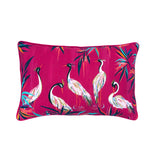 A rectangular decorative throw pillow featuring a vibrant magenta pink background printed with elegant white cranes and colorful tropical leaves.
