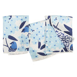 Set of four fabric swatches with blue and white floral and bird patterns on a light blue background.