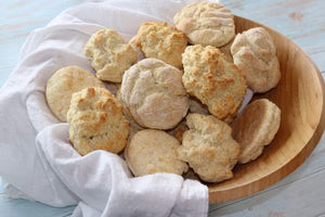 Wooden bowl filled with biscuits on a white cloth