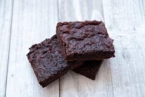 Three brownies on a light wooden surface