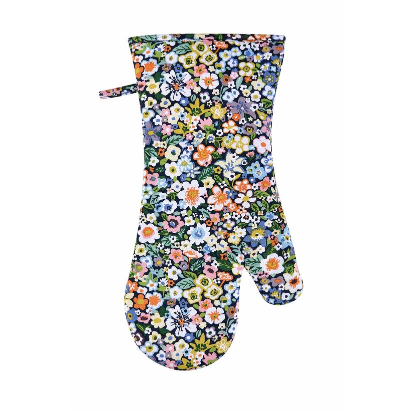 A single oven mitt with a dense, colorful floral print on a dark navy background, featuring a small matching fabric tie at the top, shown against a plain white background.