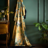 Floral-patterned fabric draped over a chair in a room with a green wall and wooden furniture.