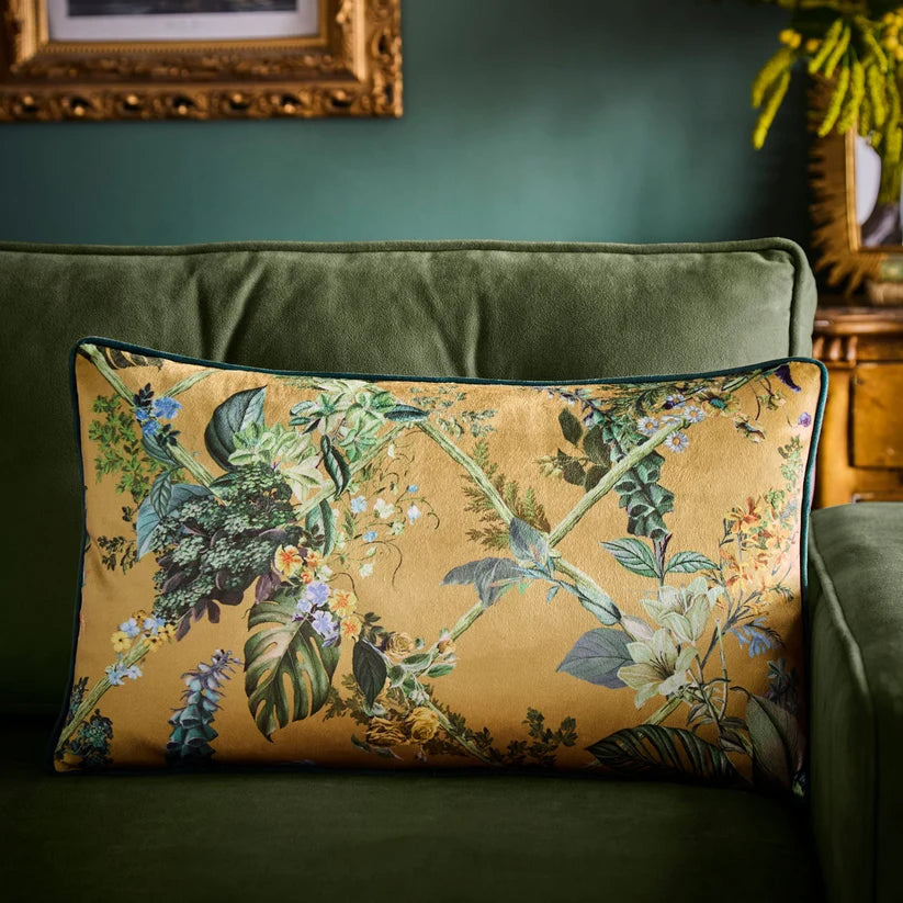 Floral-patterned pillow on a green sofa against a green wall.