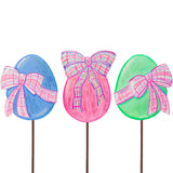Three colorful Easter egg-shaped lollipops with plaid bows on a white background