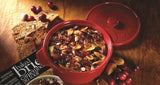Red baking dish with baked cranberry and almond mixture on a wooden surface