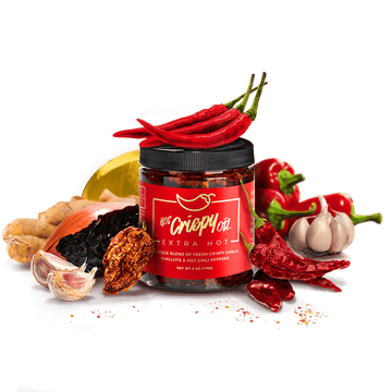 Jar of 'Red Gripe' chili paste with chili peppers, garlic, and a banana on a transparent background