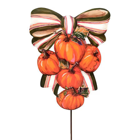 A decorative autumn garden stake featuring a cluster of orange pumpkins tied with a striped bow in red, white, and dark green, mounted on a thin black stake against a plain white background.