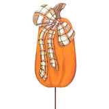 An orange decorative pumpkin sign with a brown stem and a large plaid bow in white, orange, green, and brown, mounted on a thin stake against a plain white background.