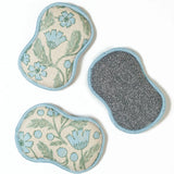Two floral-patterned pads and a gray scrubber on a white background